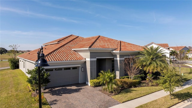 mediterranean / spanish home with a garage and a front lawn