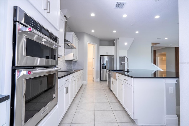 kitchen featuring light tile patterned flooring, white cabinetry, sink, decorative backsplash, and stainless steel appliances