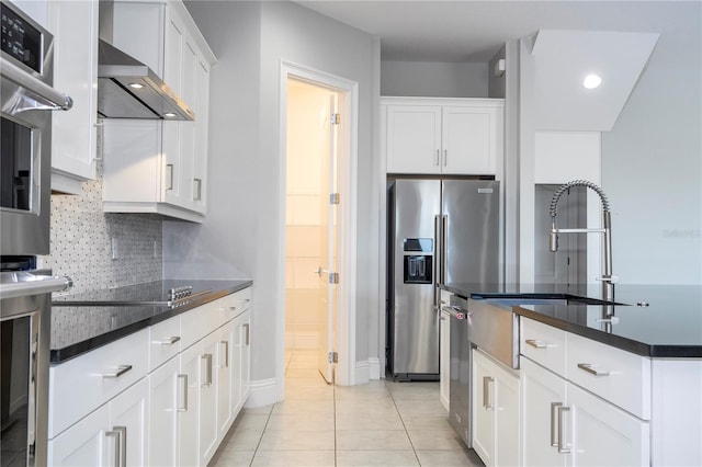 kitchen featuring stainless steel refrigerator with ice dispenser, wall chimney exhaust hood, tasteful backsplash, light tile patterned floors, and white cabinets