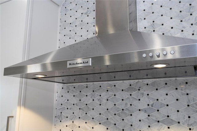 interior details with wall chimney range hood and white cabinets