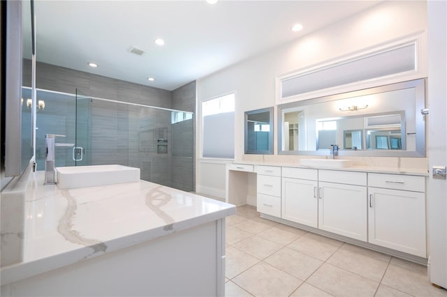 bathroom featuring vanity, walk in shower, and tile patterned flooring