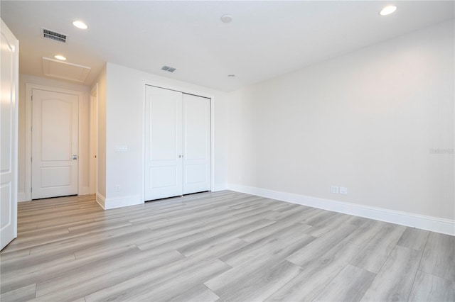 unfurnished bedroom featuring a closet and light wood-type flooring