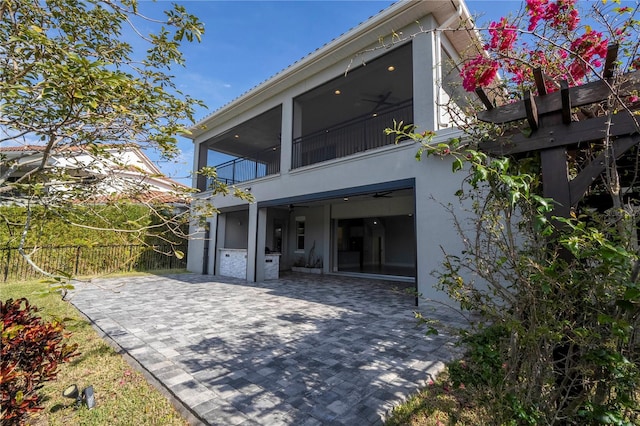 back of property with a balcony and a patio