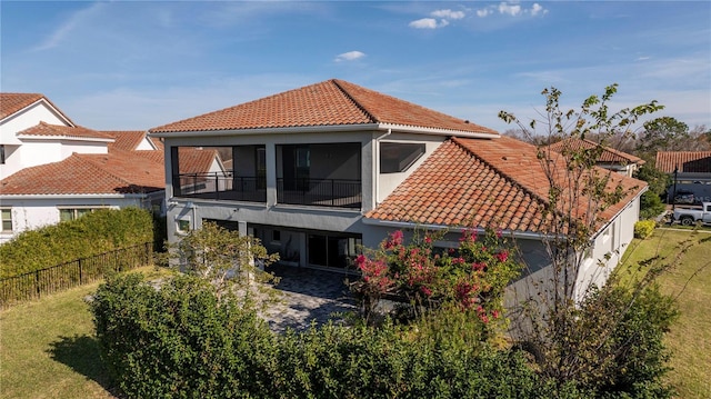 back of property with a yard and a sunroom