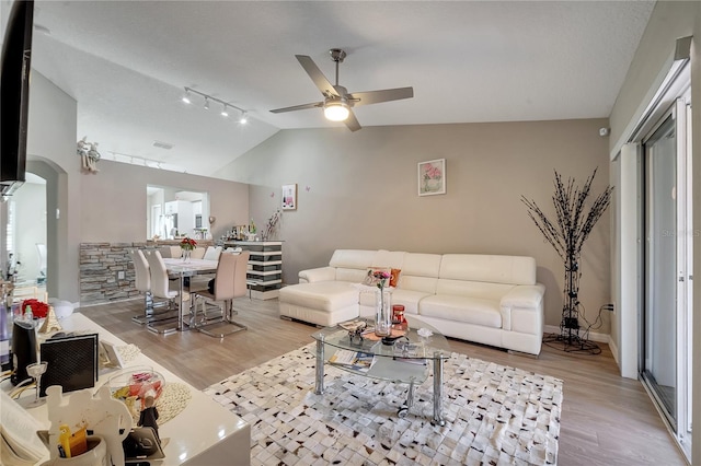 living room with light hardwood / wood-style flooring, vaulted ceiling, ceiling fan, and track lighting