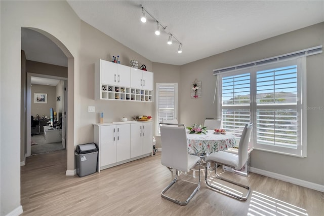 dining room with light hardwood / wood-style flooring and a textured ceiling