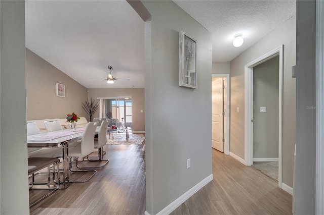 hall featuring a textured ceiling and light hardwood / wood-style floors