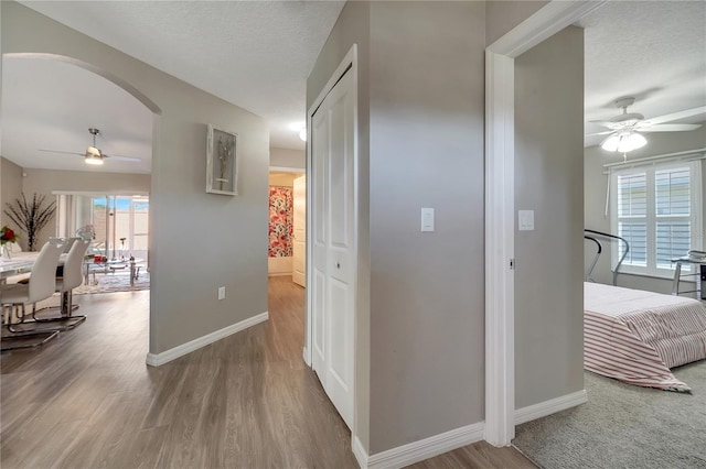 corridor featuring light hardwood / wood-style floors and a textured ceiling