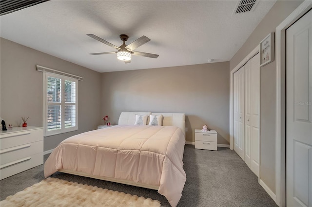 carpeted bedroom featuring ceiling fan and a textured ceiling