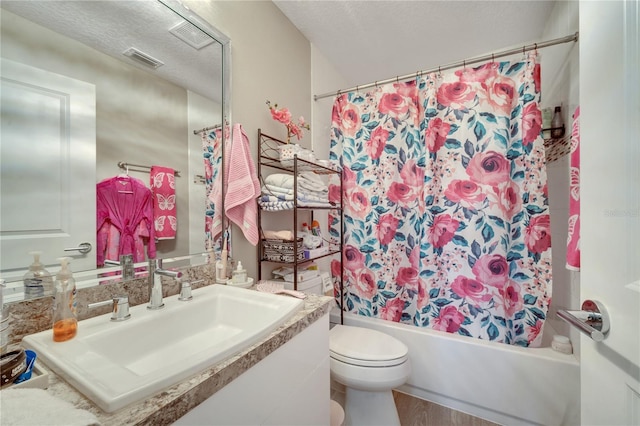 full bathroom with vanity, toilet, shower / bath combination with curtain, and a textured ceiling