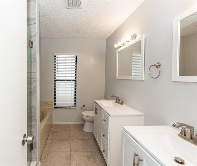 bathroom featuring two vanities, visible vents, a sink, and a textured ceiling