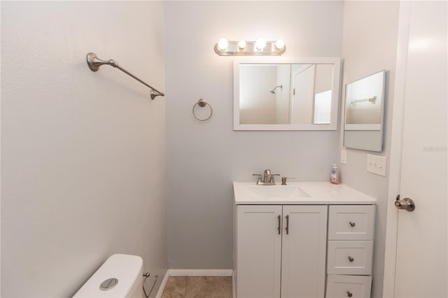 bathroom featuring tile patterned flooring, toilet, vanity, and baseboards