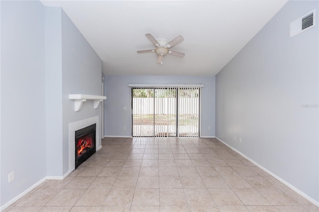 unfurnished living room with light tile patterned flooring, ceiling fan, baseboards, and a glass covered fireplace