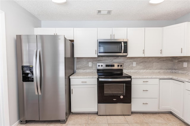 kitchen featuring stainless steel appliances, backsplash, light countertops, and visible vents