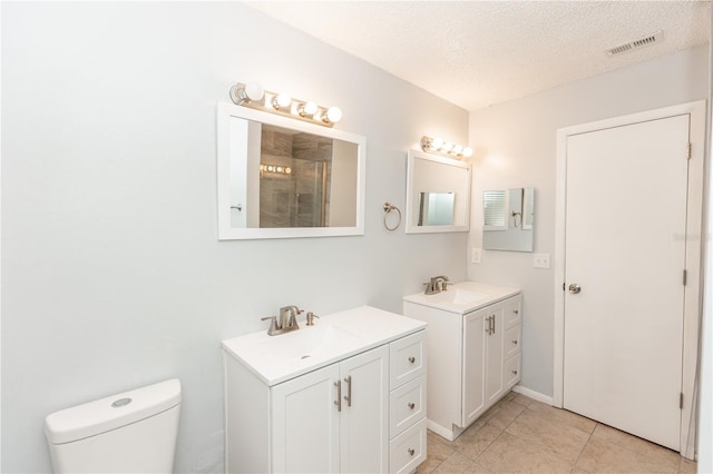 full bath featuring visible vents, a sink, a textured ceiling, and tiled shower