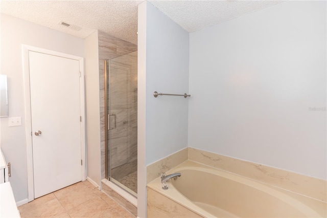 full bathroom featuring visible vents, a shower stall, a textured ceiling, a bath, and tile patterned floors