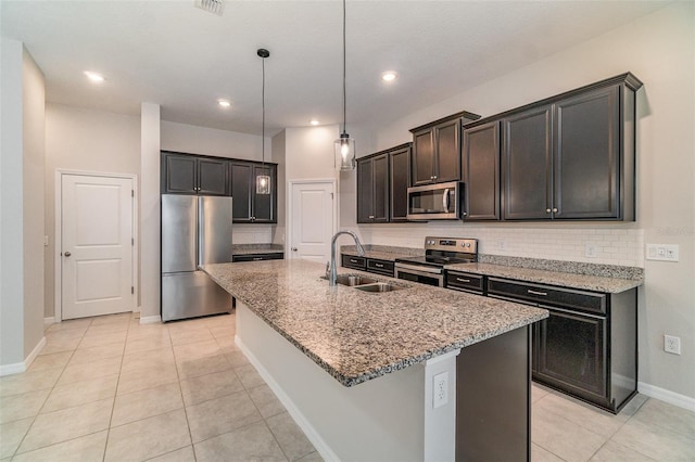 kitchen with sink, light tile patterned floors, stainless steel appliances, and a kitchen island with sink