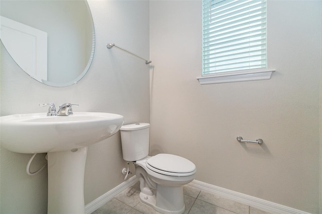 bathroom with toilet, tile patterned flooring, and sink