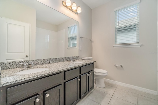 bathroom with toilet, vanity, plenty of natural light, and tile patterned floors