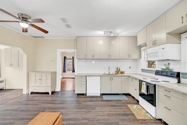 kitchen with white appliances, ceiling fan, light stone counters, dark hardwood / wood-style floors, and sink