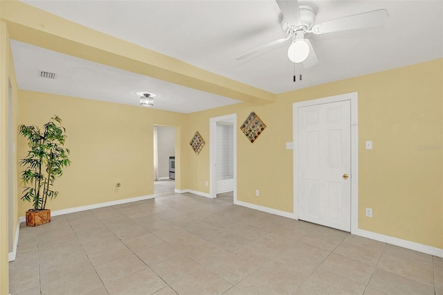 tiled spare room featuring ceiling fan