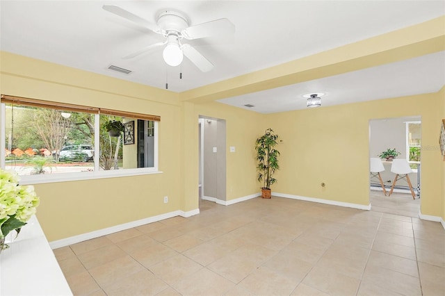 tiled spare room with baseboard heating and ceiling fan