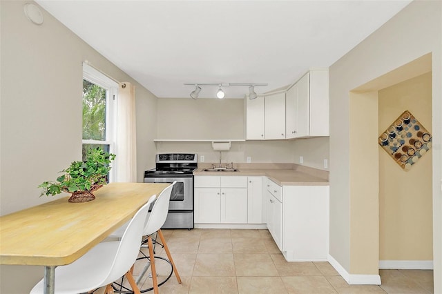 kitchen featuring white cabinets, light tile patterned flooring, electric stove, and sink