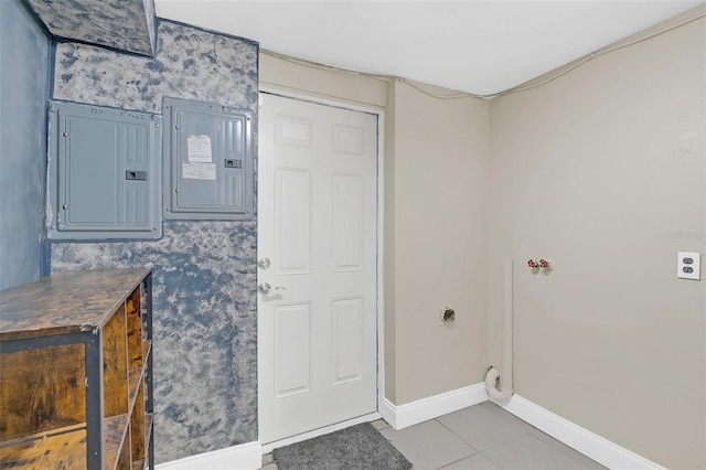 laundry area with electric panel and tile patterned floors