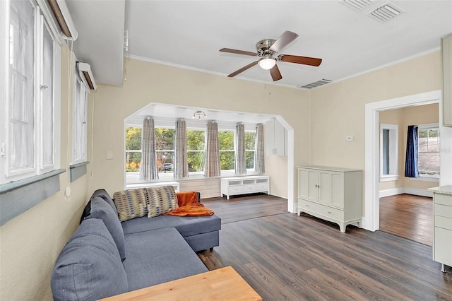 living room with dark hardwood / wood-style flooring, ceiling fan, and crown molding