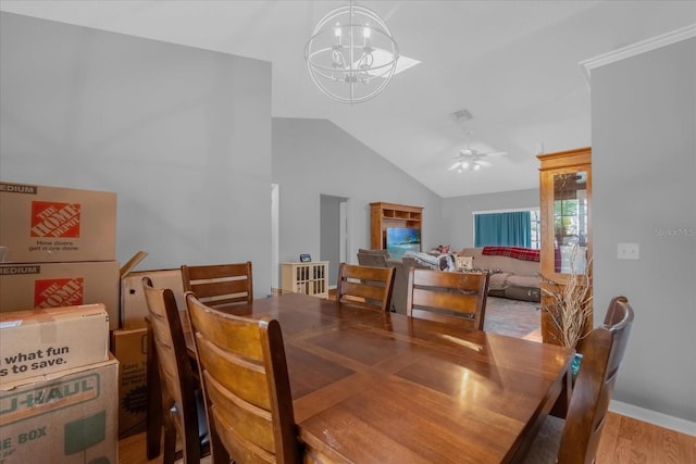 dining room featuring light wood-type flooring, vaulted ceiling, and ceiling fan with notable chandelier