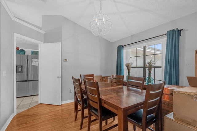 dining area with light wood-type flooring and a notable chandelier