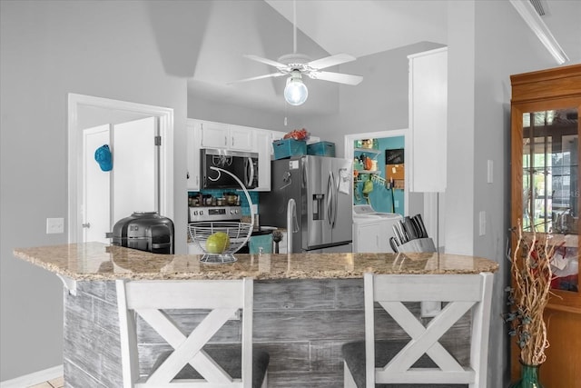 kitchen featuring white cabinetry, kitchen peninsula, ceiling fan, stainless steel appliances, and light stone counters