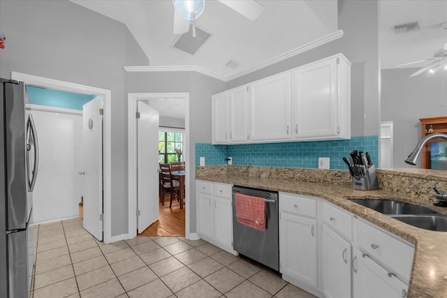 kitchen featuring white cabinets, stainless steel appliances, decorative backsplash, sink, and light tile patterned floors