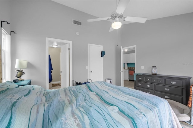 bedroom featuring ensuite bath, ceiling fan, and high vaulted ceiling