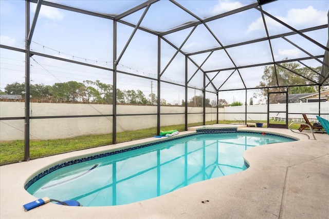 view of pool with glass enclosure and a patio