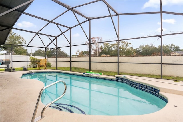 view of pool featuring glass enclosure and a patio area