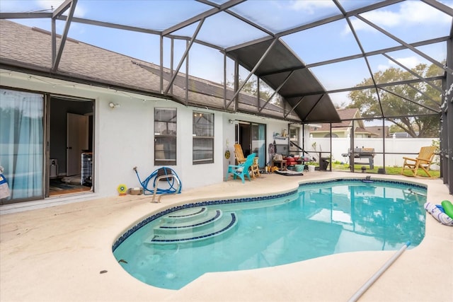 view of swimming pool featuring a patio area and glass enclosure