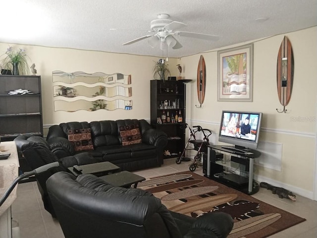 living room featuring a textured ceiling, ceiling fan, and light tile patterned floors