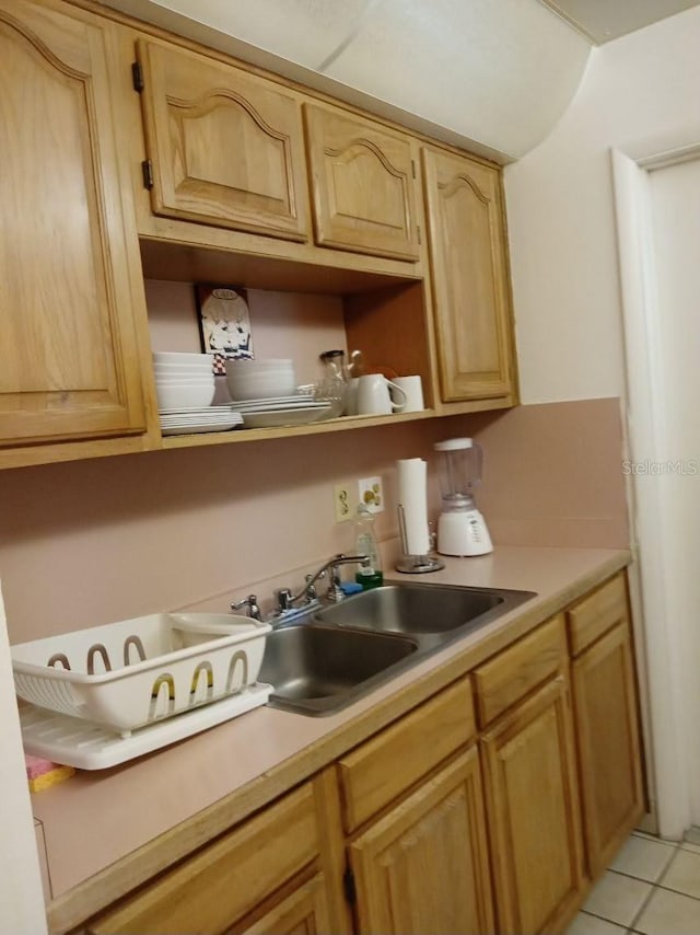 kitchen with sink, light tile patterned flooring, and light brown cabinetry