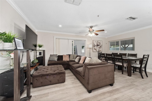 living room with ceiling fan, ornamental molding, and light hardwood / wood-style floors