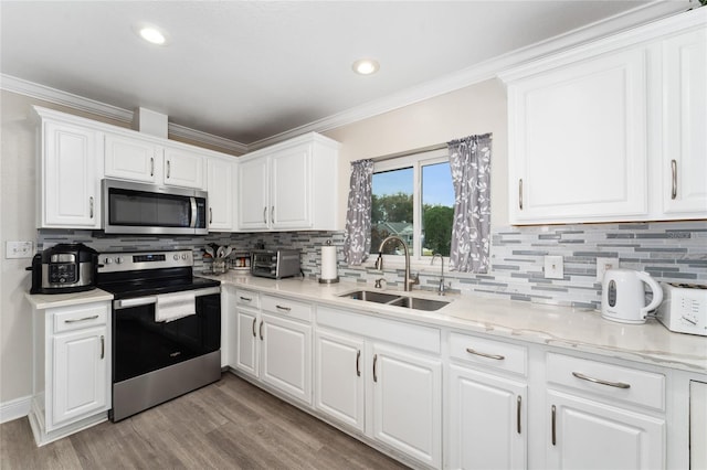 kitchen with sink, white cabinetry, crown molding, and stainless steel appliances