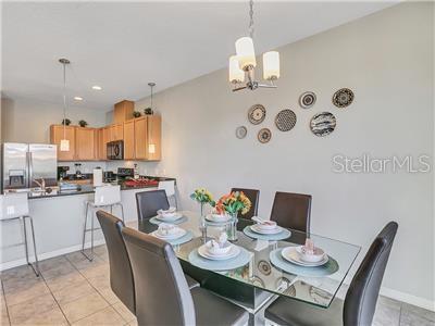 tiled dining space featuring a notable chandelier