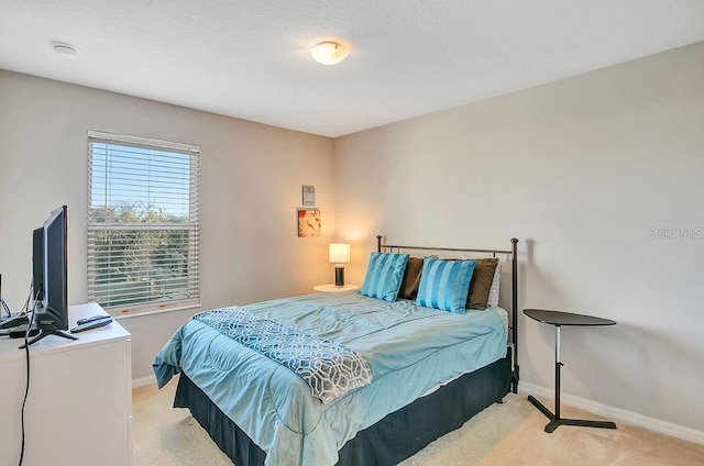 bedroom featuring light colored carpet and multiple windows