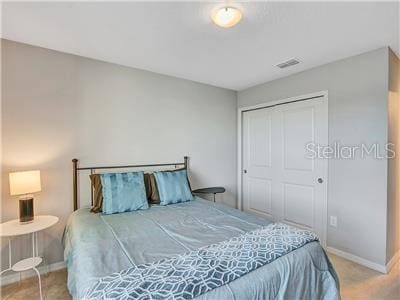 bedroom with light colored carpet and a closet