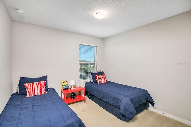 carpeted bedroom featuring a textured ceiling