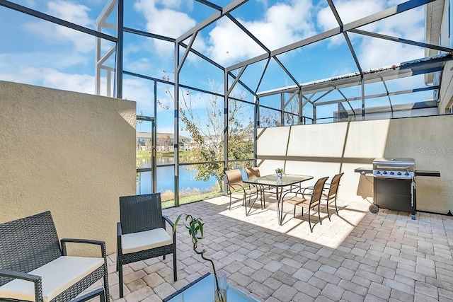 view of patio / terrace featuring a lanai, a water view, and area for grilling