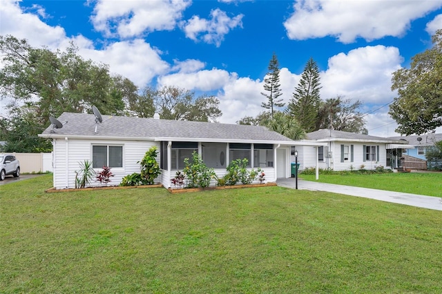 ranch-style house with a sunroom, a carport, and a front yard