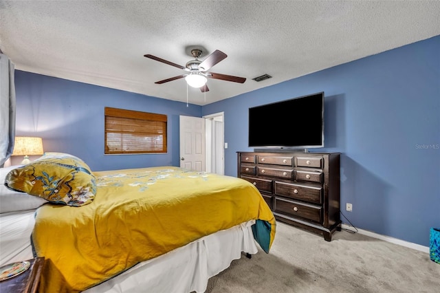 carpeted bedroom featuring a textured ceiling and ceiling fan