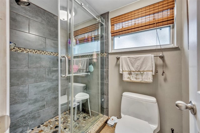 bathroom with toilet and a shower with shower door