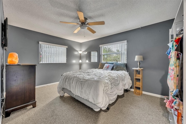 bedroom featuring ceiling fan, a textured ceiling, and carpet floors